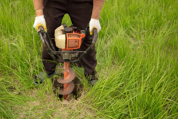 Worker drills the ground at the construction site