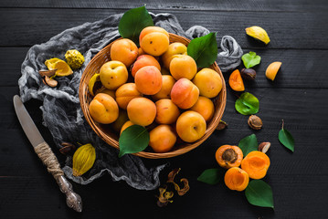 Sweet ripe apricots on black wooden background. Copy space