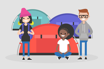 A group of young tourists seating and standing near by the tent camping