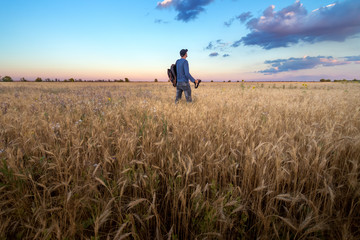 Fototapeta premium photographer while working search for a story / evening landscape man on the field