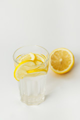  Refreshing water with lemon in a glass on a white background on a hot day