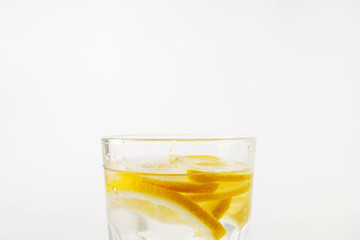  Refreshing water with lemon in a glass on a white background on a hot day