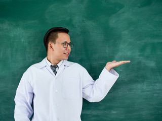 Portrait Asian Doctor standing over blackboard.