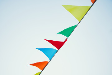 Multicolored flags develop in the wind against the background of the sky