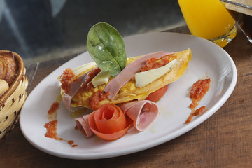 An omelette is a dish made from beaten eggs fried with butter or oil in a frying pan. Into the omelette it is added cheese, chives, mushrooms, or ham.