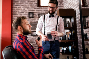 Customer spray perfume on beard after treatment