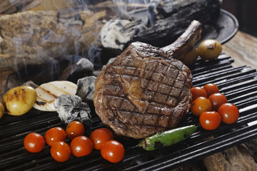 Grilled Tomahawk served with roasted chiles, potatoes and cherry tomatoes. This steak with the long...