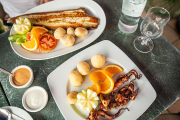 Above view of tasty fried fish and sea fruits with potato and sauce from tomato and chili re paper. Delicious restaurant food near ocean in Spain, Canarias island. Traditional Canarias dish.