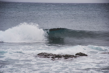 typical windy day in gran canaria, canary islands, spain. ideal for surfing, bigger waves in the sea, turquoise blue water in the ocean