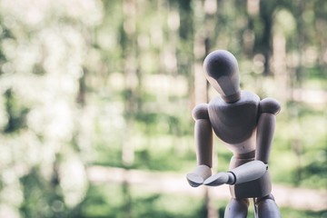 Wooden mannequin with outstretched hands like asking something. Nature background. Thoned photo. - obrazy, fototapety, plakaty