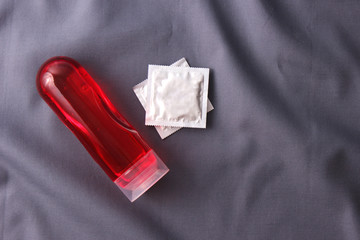 an intimate lubrication against the background of a sheet from above. Intimate gel, comfortable sex.