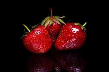Ripe strawberry with reflection on a black background
