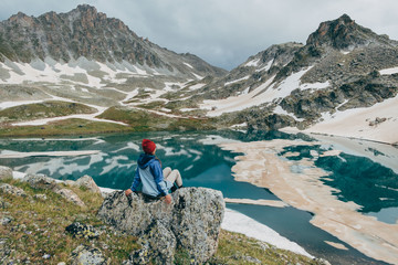 young trekking girl sits nearby mountain snowy lake landscape