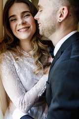 Wedding couple indoors is hugging each other. Beautiful bride in