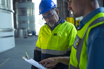 Engineers in industrial plant discussing work