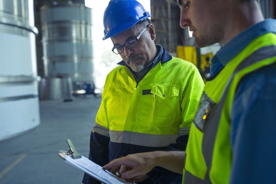Engineers in industrial plant discussing work
