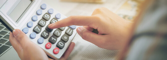 Woman accountant or bank worker uses calculator.