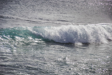 typical windy day in gran canaria, canary islands, spain. ideal for surfing, bigger waves in the sea, turquoise blue water in the ocean
