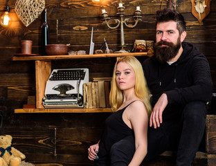 Couple spend romantic evening in gamekeepers house, wooden interior background. Couple in love hugs, cuddling together. Romantic concept. Girl and man on calm faces relax in warm atmosphere