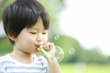 シャボン玉で遊ぶ男の子