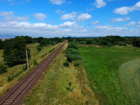 Electric railroad in a green natural environment, meadows, trees, grass, aerial view