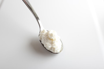 cottage cheese yogurt in a spoon on a white background