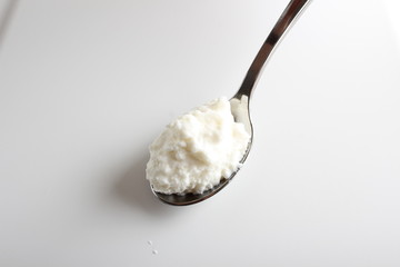 cottage cheese yogurt in a spoon on a white background