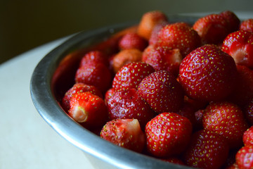 large red berries of juicy strawberry are in a bowl. Close up