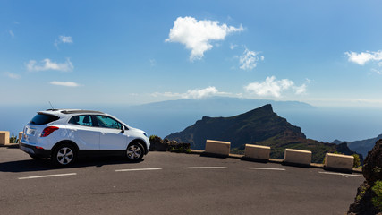 Sight on mountain and La Gomera island  with white car on road, from Tenerife, near Masca village