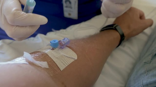 Removing intravenous drip from arm and giving a saline flush