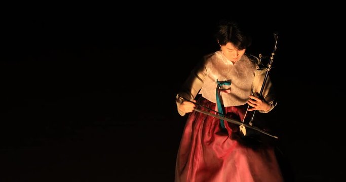 Korean female musician playing the Haegeum which is the Korean traditional string instrument on stage