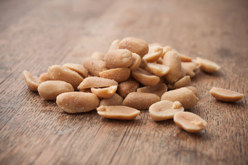 closeup of salted peanuts on wooden background