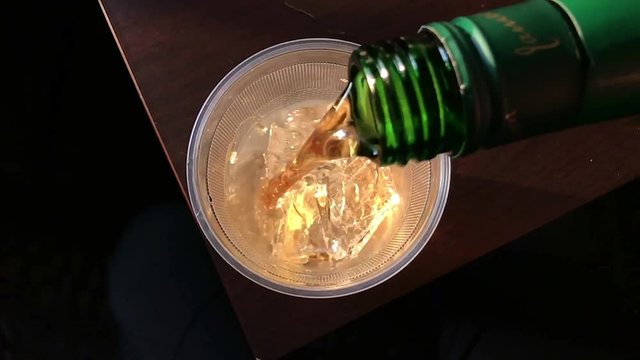 A serving of Irish Whiskey is poured over ice in Slow Motion.