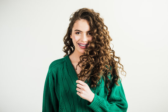 Fashion woman in green sweater. Fashion look and beauty concept. girl with curly hair at hairdresser at white wall. Retro girl with stylish makeup and hair in paris. Parisian girl in winter clothes