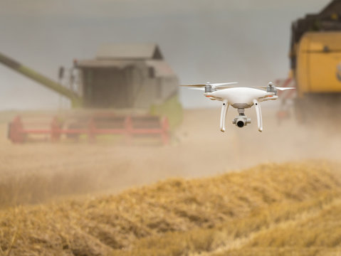 Drone flying in front of combine harvesters