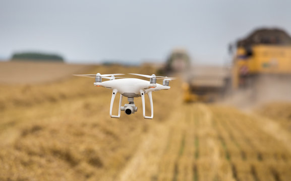 Drone flying in front of combine harvesters