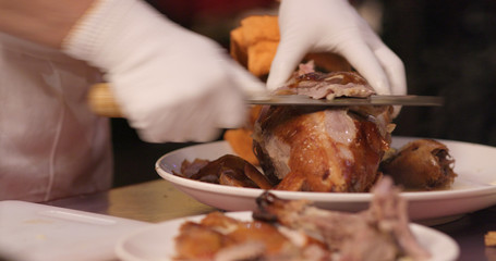 Obraz na płótnie Canvas Chef cutting of grilled duck in restaurant