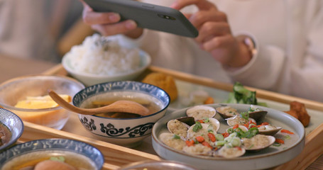 Woman taking photo on her dishes in Taiwanese restaurant