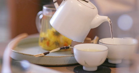Pouring tea to a cup in restaurant
