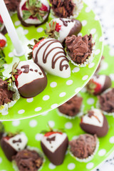 close up fancy strawberry chocolate handmade for a party on bright green plate