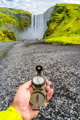 Wonderful, high and huge Skogarfoss waterfall and compass in hand, on South Iceland