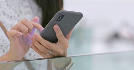 Close up Woman using mobile phone inside shopping plaza