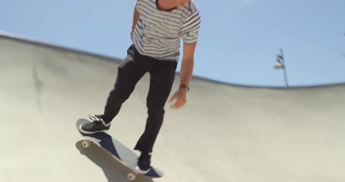 Low angle of man skateboarding doing extreme air off ramp isolated in sky on sunny day 