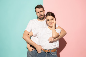 Fototapeta premium Wow. Doubtful pensive couple with thoughtful expression making choice against pink background