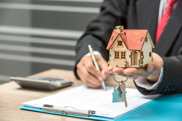 business man hand key and house model