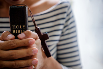 Christian woman praying on holy bible. Hands folded in prayer a holy bible in church concept