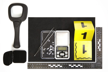Seized contraband of smuggled diamonds, magnifier and pad documented by police