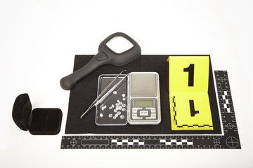 Seized contraband of smuggled diamonds, magnifier and pad documented by police