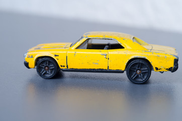 Old yellow car. Side view. Shallow depth of field on a gray backgroun