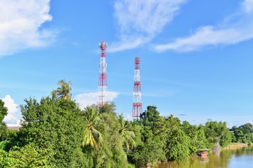 Obraz premium View of Lush Green Forests with Red and White High-Voltage Transmission Tower 